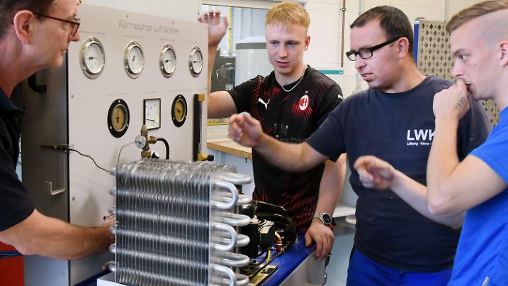 11.08.2022, Sachsen, Borsdorf: Im Bildungs- und Technologiezentrum der Handwerkskammer zu Leipzig erklärt Ausbilder Stefan Schwammbach (l) angehenden Anlagenmechanikern für Elektro-, Mess-, Steuer- und Regelungstechnik aus dem 4. Lehrjahr eine Wärmepumpe. Die Azubis gehören zu zahlreichen jungen Menschen in Sachsen, die sich für eine Lehre im Handwerk entschieden haben. Trotzdem sind hunderte Stellen im Handwerk weiterhin frei. Die Betriebe suchen händeringend nach Nachwuchs. (zu dpa "Handwerker gesucht: In Sachsens Betrieben ist der Nachwuchs rar") Foto: Waltraud Grubitzsch/dpa-Zentralbild/dpa +++ dpa-Bildfunk +++