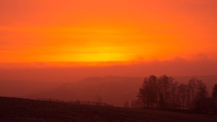 17.03.2022, Sachsen, Bärenstein: Wegen des Saharastaub in der Luft ist der Himmel bei Sonnenaufgang rötlich gefärbt. Foto: Oliver Kaufmann/promovie/dpa +++ dpa-Bildfunk +++