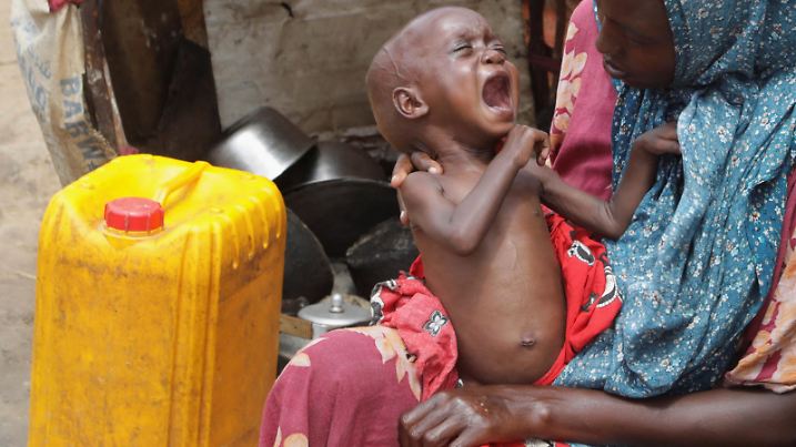 Amina Ali, a Somali woman affected by the worsening drought due to failed rain seasons, holds her child inside their makeshift shelter at the Alla Futo camp for internally displaced people in the outskirts of Mogadishu, Somalia September 23, 2022. REUTERS/Feisal Omar