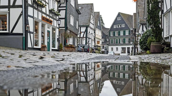 News Bilder des Tages Tristesse in der Altstadt von Freudenberg, einem beliebten Touristenziel, Reiseziel in Suedwestfalen. Die Fachwerkhaeuser spiegeln sich in einer Pfuetze Winter im Siegerland am 03.02.2022 in Freudenberg/Deutschland. *** Dreariness in the old town of Freudenberg, a popular tourist destination, tourist destination in South Westphalia The half-timbered houses are reflected in a puddle winter in the Siegerland on 03 02 2022 in Freudenberg Germany