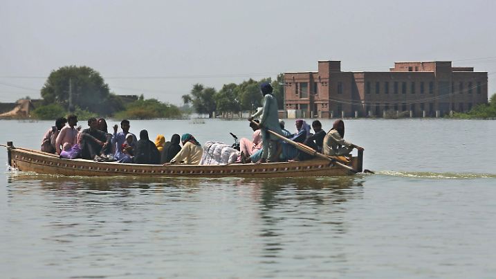 22.09.2022, Pakistan, Dadu: Dorfbewohner mit ihren Habseligkeiten und Motorradfahrer überqueren ein überschwemmtes Gebiet in einem Boot. 
Der Monsun habe eine Fläche fast so groß wie die Bundesrepublik unter Wasser gesetzt, sagte Bundesaußenministerin Baerbock. Viele Menschen litten unter Krankheiten wie Malaria. Die Flut habe vor Augen geführt, welche dramatischen Konsequenzen die Klimakrise in allen Regionen der Erde habe. «Als eines der weltweit am stärksten betroffenen Länder zahlt Pakistan derzeit einen hohen Preis für den globalen CO2-Ausstoß.» Deutschland werde sich deswegen bei der Weltklimakonferenz in Ägypten im November für eine faire Verteilung der Klimakosten einsetzen. Foto: Fareed Khan/AP/dpa +++ dpa-Bildfunk +++