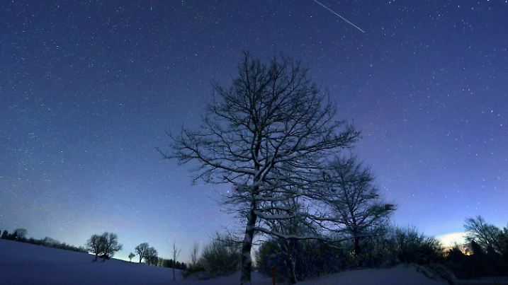 ARCHIV - 12.12.2021, Bayern, Wertach: Ein Sternschnuppe verglüht am sternenklaren Himmel über der schneebedeckten Allgäuer Landschaft kurz vor Sonnenaufgang. Mit den Geminiden bietet der Himmel Mitte Dezember den reichsten Sternschnuppenstrom des Jahres. (zu dpa "Spektakel am Nachthimmel - Geminiden-Sternschnuppen Mitte Dezember") Foto: Karl-Josef Hildenbrand/dpa +++ dpa-Bildfunk +++