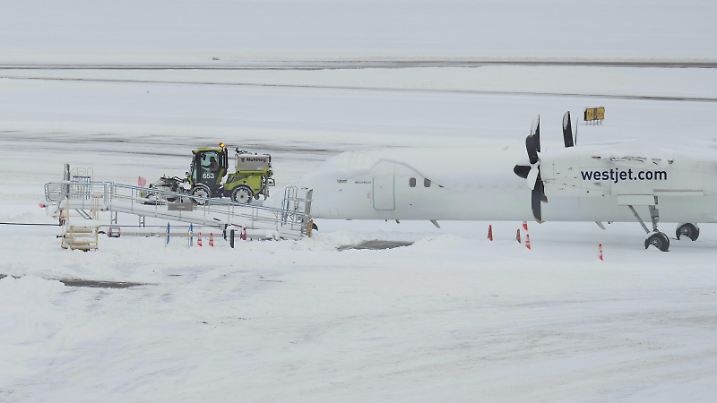 December 20, 2022, RICHMOND, BC, CANADA: A worker clears snow on the apron near a Westjet aircraft at Vancouver International Airport after a snowstorm crippled operations leading to cancellations and major delays, in Richmond, B.C., on Tuesday, December 20, 2022. RICHMOND CANADA PUBLICATIONxINxGERxSUIxAUTxONLY - ZUMAc35_ 20221220_zaf_c35_045 Copyright: xDarrylxDyckx