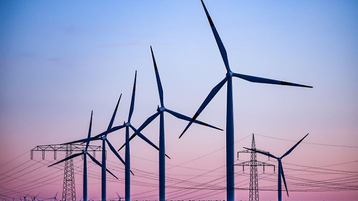 ARCHIV - 04.10.2022, Sachsen-Anhalt, Leuna: Windkraftanlagen und Hochspannungsleitungen sind vor dem Abendhimmel bei Leuna zu sehen. Erneuerbare Energien haben in diesem Jahr mit rund 47 Prozent fast die Hälfte des Bruttostromverbrauchs in Deutschland gedeckt. (zu dpa «Öko-Energie deckt 2022 fast die Hälfte des Stromverbrauchs») Foto: Jan Woitas/dpa +++ dpa-Bildfunk +++