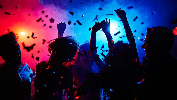 Silhouettes of dancers moving in confetti