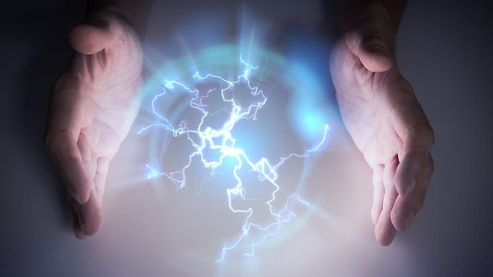 Plasma or electric lightning around hanbds of magician.