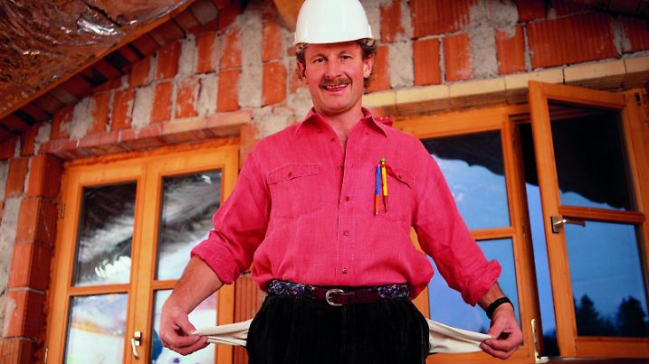 Handwerker in Rohbau, zeigt leere Taschen