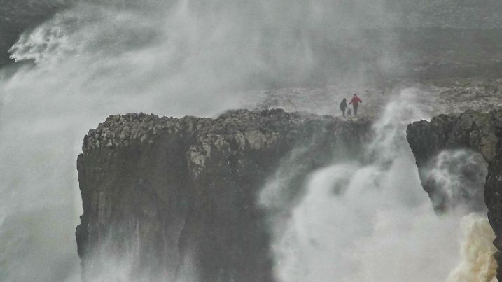 16.01.2023, Spanien, Llanes: Zwei Personen spazieren entlang der Klippen von Pría in Llanes, Asturien. Der Sturm «Gerard» hat Spanien am Montag mit Wind, Wellen, Schnee und Regen heimgesucht. Foto: Xuan Cueto/EUROPA PRESS/dpa +++ dpa-Bildfunk +++