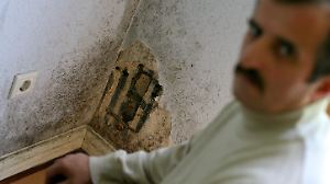 Adem Cirak sitzt am Mittwoch (07.06.2006) in seinem von Schimmel befallenem Schlafzimmer in der Kiefernstraße in Düsseldorf. Lange Zeit war sie die größte Hausbesetzer-Szene Deutschlands: In den 80er Jahren geriet die Düsseldorfer Kiefernstraße durch Großeinsätze der Polizei und als angeblicher Unterschlupf von RAF-Terroristen immer wieder in die Schlagzeilen. Schließlich schloss die Stadt 1988 als Besitzerin der Häuser mit den Bewohnern Mietverträge zu äußerst günstigen Konditionen. Doch nun rumort es wieder in der bunt bemalten Häuserzeile. Schimmelbefall, auslaufende Mietverträge und die Sanierungspläne der Stadt rufen die Mieter auf den Plan. Foto: Felix Heyder dpa/lnw (zu dpa-KORR: "Schimmel in der Kiefernstraße - Ehemalige Hausbesetzerszene verärgert" vom 11.06.2006) +++(c) dpa - Bildfunk+++