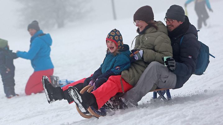 22.01.2023, Sachsen-Anhalt, Wernigerode: Kinder und Erwachsene fahren in Drei Annen Hohne mit ihren Schlitten. In weiten Teilen des Harzes gab es in der Nacht zum Sonntag ergiebige Schneefälle. Das Winterwetter lockte am Wochenende zahlreiche Besucher in die Harzregion. Foto: Matthias Bein/dpa +++ dpa-Bildfunk +++