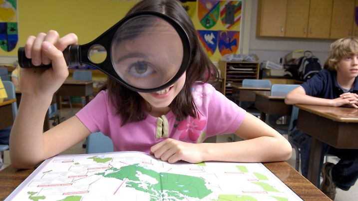 Girl Explores Atlas with Magnifying Glass. || Modellfreigabe vorhanden