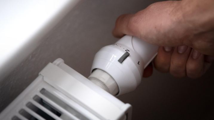 ARCHIV - 25.09.2020, Bremen: ILLUSTRATION - Ein Mann dreht am Thermostat einer Heizung. (zu dpa «Land spart Gas und Strom ein» Foto: Sina Schuldt/dpa +++ dpa-Bildfunk +++