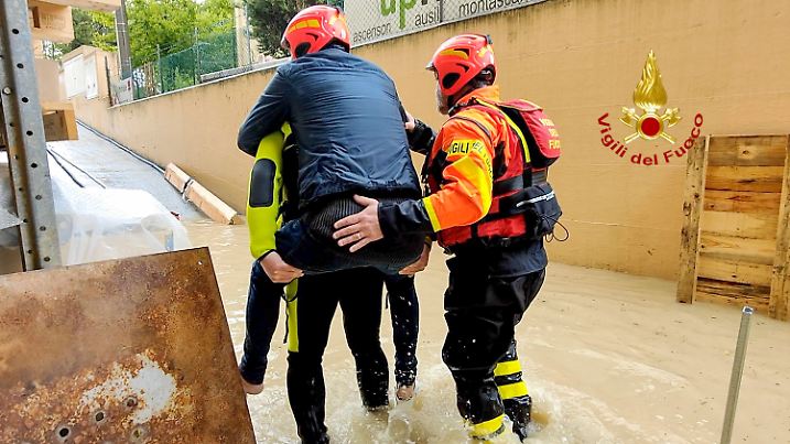HANDOUT - 16.05.2023, Italien, Senigallia: Dieses von der italienischen Feuerwehr zur Verfügung gestellte Bild zeigt Feuerwehrleute, die eine Person aus einem überfluteten Haus in Riccione in der norditalienischen Region Emilia Romagna retten. Ungewöhnlich starke Regenfälle haben zu schweren Überschwemmungen geführt. Foto: Uncredited/Vigili del Fuoco/AP/dpa - ACHTUNG: Nur zur redaktionellen Verwendung im Zusammenhang mit der aktuellen Berichterstattung innerhalb der nächsten 14 Tage und nur mit vollständiger Nennung des vorstehenden Credits +++ dpa-Bildfunk +++