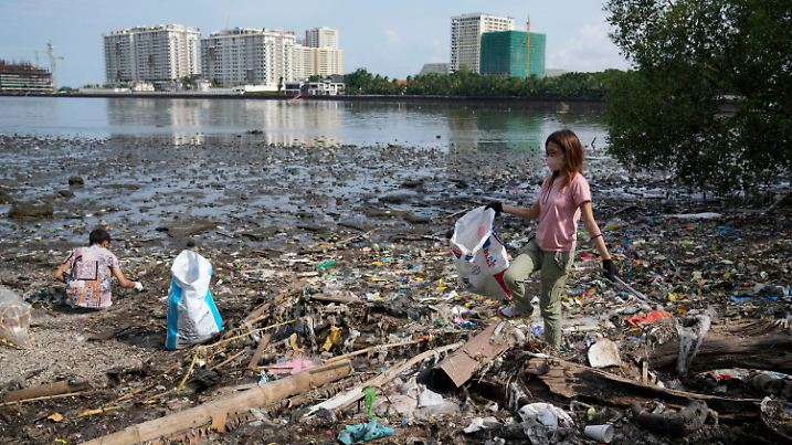 ARCHIV - 16.09.2022, Philippinen, Manila: Freiwillige sammeln in einem verschmutzten Küstengebiet  Müll auf. (zu dpa: «UN-Konferenz in Paris berät über globales Abkommen gegen Plastikmüll») Foto: Aaron Favila/AP +++ dpa-Bildfunk +++