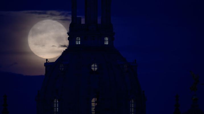 05.05.2023, Sachsen, Dresden: Der Mond geht am Morgen hinter der Frauenkirche unter. Foto: Robert Michael/dpa +++ dpa-Bildfunk +++