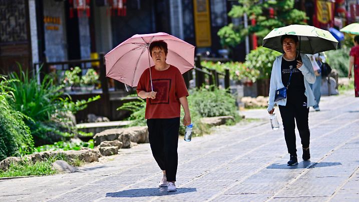 QINGZHOU, CHINA - JUNE 15, 2023 - Tourists hold umbrellas while walking in high temperatures in Qingzhou Ancient City, East China's Shandong province, June 15, 2023.