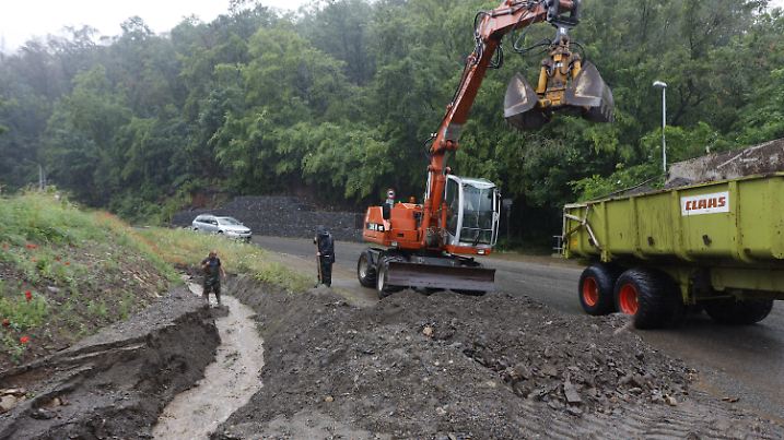23.06.2023, Sachsen-Anhalt, Thale: Mitarbeiter des Bauhofes legen einen Graben in Thale frei. Am Tag nach dem Unwetter laufen die Aufräumarbeiten auf Hochtouren. Insbesondere im Landkreis Harz waren mehrere Orte wie Thale , direkt vom Unwetter betroffen. In Thale haben Wassermassen tonnenweise Geröll auf eine Straße und in einen Wassergraben gespült. Die Straße wurde bis zum Mittag gesperrt. Foto: Matthias Bein/dpa +++ dpa-Bildfunk +++