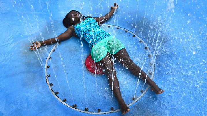 With the temperature in the mid 90's, Carliya Dove, 12, soaks up the full effects of the play fountain in Julius Guinyard Park in Jacksonville, Fla., to beat the afternoon heat on Wednesday July 20, 2016. (Bob Mack/The Florida Times-Union via AP)