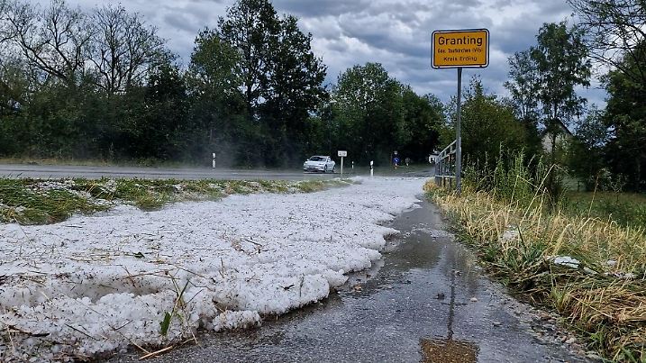 12.07.2023, Bayern, Taufkirchen Ot Granting: Hagelkörner liegen nach einem Unwetter am Straßenrand vom Ortseingang Taufkirchen OT Granting im Landkreis Erding. (Usage only in Germany) Foto: Hutter/Vifogra/dpa +++ dpa-Bildfunk +++