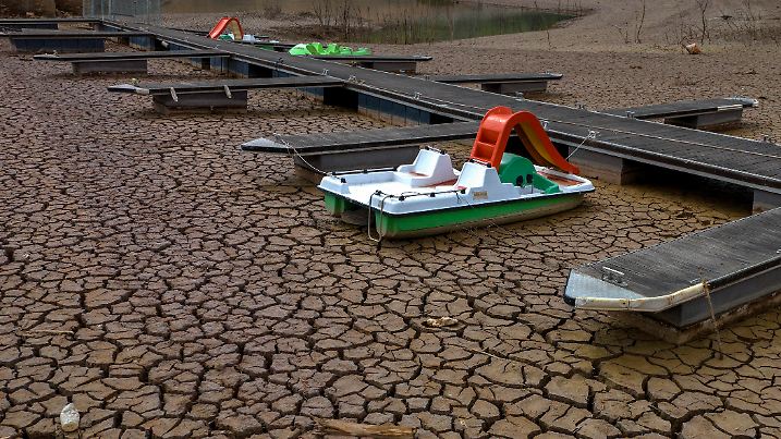 18.04.2023, Spanien, Vilanova de Sau: Ein Tretboot ist an einem Steg in einem ausgetrockneten Teil des Sau-Stausees, etwa 100 km nördlich von Barcelona, festgemacht. Der spanische Ministerpräsident Sanchez warnte seine Amtskollegen am Mittwoch, dass die akute Dürre, die das Land heimsucht, zu einer der größten langfristigen Sorgen des Landes werden wird. Foto: Emilio Morenatti/AP +++ dpa-Bildfunk +++