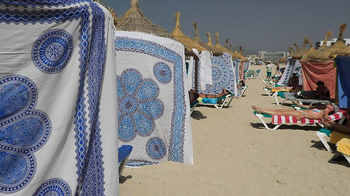 18.07.2023, Spanien, Palma de Mallorca: Menschen schützen sich bei heißen Temperaturen mit Strandtüchern vor der Sonne am Strand von Arenal. Für den Norden und Osten der spanischen Mittelmeer-Insel Mallorca kündigte der nationale Wetterdienst Aemet Höchsttemperaturen von mindestens 43 Grad an. Der Höhepunkt der dritten Hitzewelle des Sommers in Spanien bringt Einheimische und Touristen im beliebten Urlaubsland ins Schwitzen. Foto: Clara Margais/dpa +++ dpa-Bildfunk +++