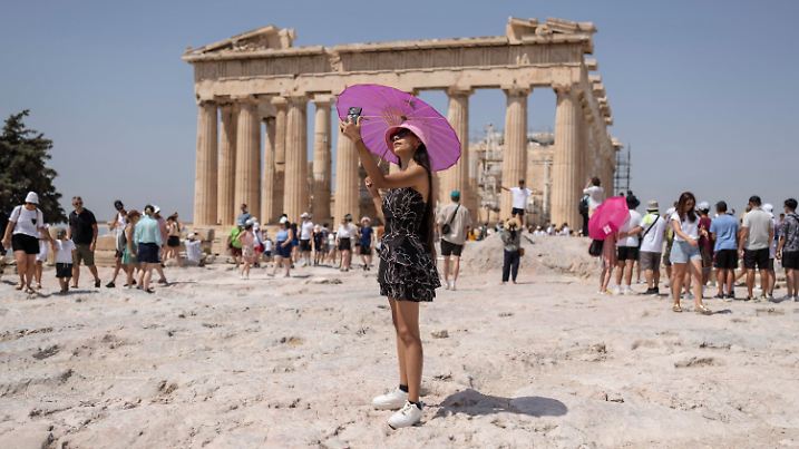 21.07.2023, Griechenland, Athen: Eine Frau macht während einer Hitzewelle ein Selfie vor dem Parthenon-Tempel auf dem Hügel der antiken Akropolis. Griechenland geht in die dritte Hitzewelle des Jahres - am Freitag (21.07.2023) sollen die Temperaturen vielerorts auf 40 Grad steigen, am Samstag (22.07.2023) auf 43 und am Sonntag (23.07.2023) in Mittelgriechenland und der Hauptstadt Athen sogar auf bis zu 44 Grad, wie es auf der staatlichen Wetterwebsite Meteo hieß. Foto: Petros Giannakouris/AP/dpa +++ dpa-Bildfunk +++