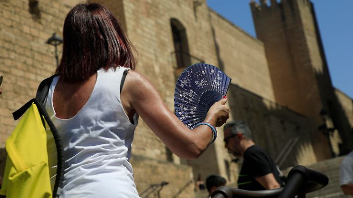 ARCHIV - 19.07.2023, Spanien, Palma: Eine Frau mit einem Fächer geht während einer Hitzewelle in der Innenstadt von Palma spazieren. Manche Reiseziele sind absolute Klassiker für Urlauber aus Deutschland. Doch im Süden Europas wüten Waldbrände und Hitze. Verändert das auf lange Sicht die Auswahl unserer Reiseziele? (zu dpa «Wie sich die Klimakrise auf beliebte Reiseländer auswirkt») Foto: Clara Margais/dpa +++ dpa-Bildfunk +++