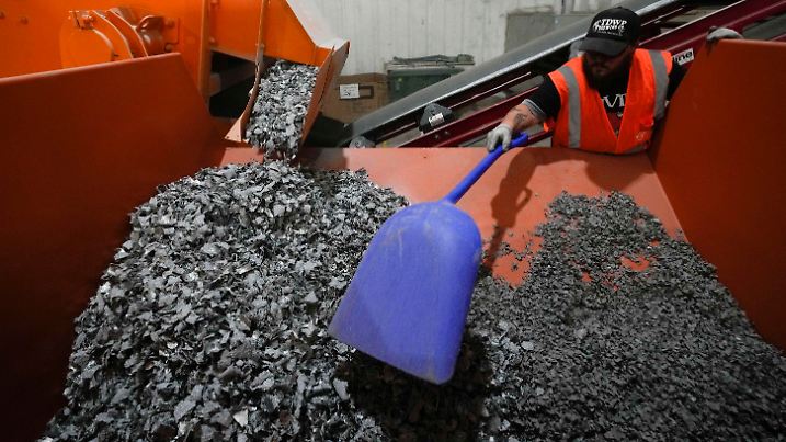 K.C. Skillern moves material with a shovel from recycled solar panels at We Recycle Solar on Tuesday, June 6, 2023, in Yuma, Ariz. North America’s first utility-scale solar panel recycling plant opened to address what founders of the company call a “tsunami” of solar waste, as technology that became popular in the early 2000s rapidly scales up. (AP Photo/Gregory Bull)