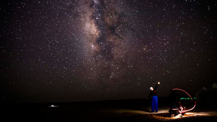 12.08.2023, Ägypten, Faijum: Personen beobachten den Perseiden-Meteoritenschauer über dem Naturschutzgebiet über dem Wadi al-Hitan («Tal der Wale»). Foto: Gehad Hamdy/dpa +++ dpa-Bildfunk +++