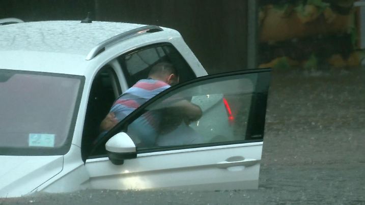 17.08.2023, Bayern, Nürnberg: Einer Person wird aus dem Auto bei einer überschwemmten Unterführung geholfen. Starkregen hat in Nürnberg am Donnerstagabend zu zahlreichen Einsätzen von Polizei und Feuerwehr geführt. Viele Keller und Tiefgaragen seien vollgelaufen, in Unterführungen seien Autos im Wasser stehen geblieben und Insassen eingeschlossen gewesen. Foto: Oßwald/News5 /dpa +++ dpa-Bildfunk +++
