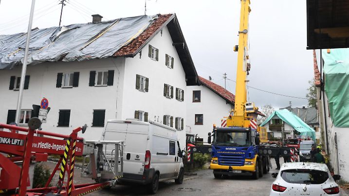 27.08.2023, Bayern, Bad Bayersoien: Nach dem Unwetter im Landkreis Garmisch-Partenkirchen sind die Dächer mehrerer Wohnhäuser mit Planen provisorisch abgedeckt. Aufgrund schwerer Unwetterschäden rief das Landratsamt Garmisch-Partenkirchen für den Ort mit rund 1300 Einwohnern am Sonntag den Katastrophenfall aus. 80 Prozent der Gebäude in dem Ort sollen schwer beschädigt sein. Foto: Felix Hörhager/dpa +++ dpa-Bildfunk +++