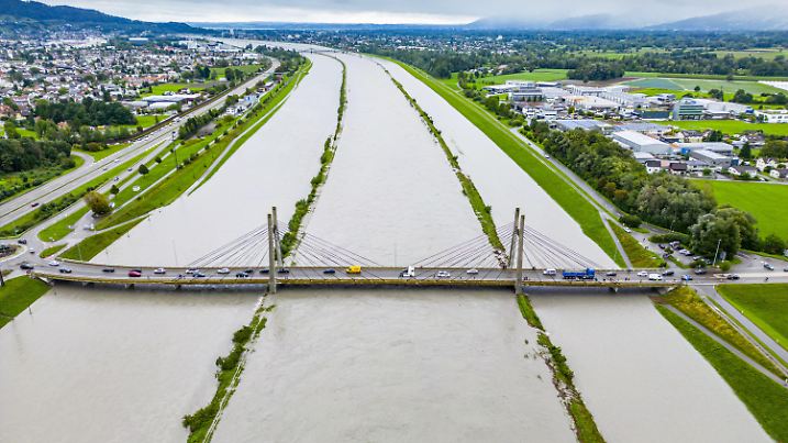28.08.2023, Schweiz, Diepoldsau: Im Rheintal fluten die Wassermassen das Land zwischen den Dämmen (Foto mit Drohne). Der Rhein führt nach starken Regenfällen Hochwasser. Besonders im Süden und Osten der Schweiz kam es zu starken Regenfällen. Foto: Yanik Buerkli/KEYSTONE/dpa +++ dpa-Bildfunk +++