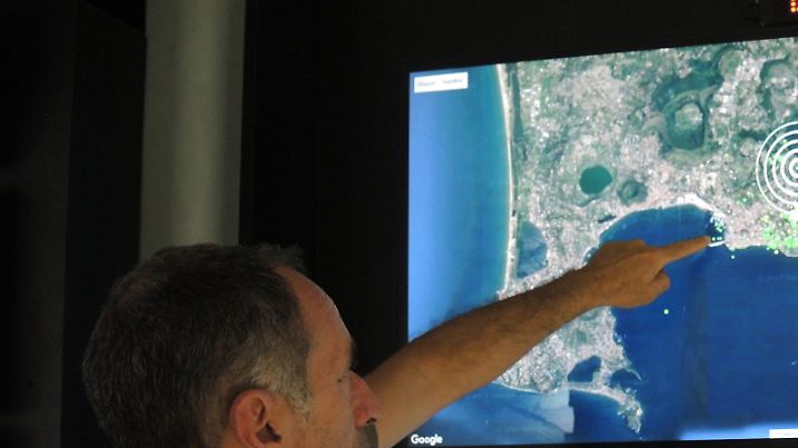 Der Geologe Roberto Isaia zeigt im Vulkan-Observatorium des Nationalen Instituts für Geophysik und Vulkanologie (INGV) in Neapel (Italien) am 16.06.2017 auf eine Satellitenaufnahme des Golfs von Neapel. Rund um die Uhr werden hier die Vulkane Vesuv, Phlegräische Felder und Ischia überwacht. (zu dpa «Der Vulkanriese in der Tiefe - «Wir stecken im Schlamassel»» vom 05.07.2017) Foto: Lena Klimkeit/dpa +++(c) dpa - Bildfunk+++