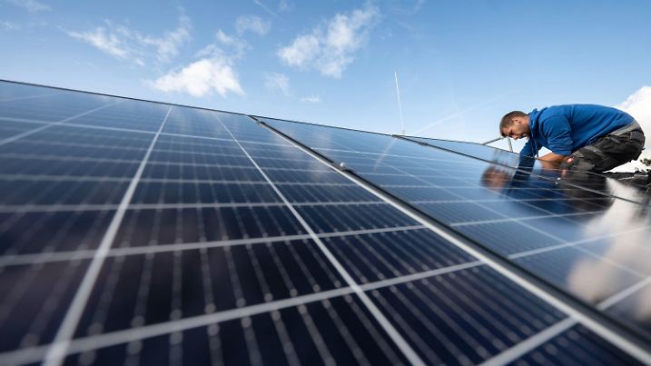 ARCHIV - 13.10.2021, Baden-Württemberg, Stuttgart: Mitarbeiter montieren Photovoltaikmodule auf dem Dach eines Wohnhauses. Die europäische Solarbranche rechnet in den nächsten Jahren mit einem Bedarf von mehreren hunderttausend zusätzlichen Fachkräften. (zu dpa «Solarbranche braucht hunderttausende Fachkräfte») Foto: Marijan Murat/dpa +++ dpa-Bildfunk +++
