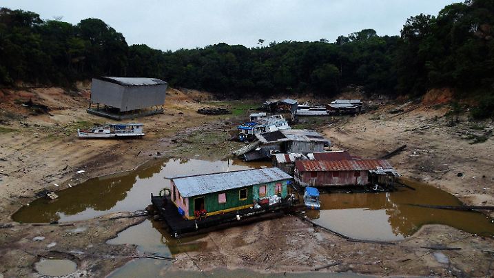 16.10.2023, Brasilien, Manaus: Boote und Hausboote stehen in einem trockenen Bereich des Flusses Negro während einer Dürre in Manaus im brasilianischen Bundesstaat Amazonas. Der zweitgrößte Nebenfluss des Amazonas erreichte am Montag den niedrigsten Stand seit Beginn der offiziellen Messungen in der Nähe von Manaus vor mehr als 120 Jahren. Foto: Edmar Barros/AP/dpa +++ dpa-Bildfunk +++