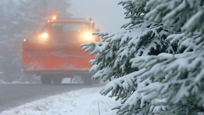 11.11.2023, Sachsen-Anhalt, Schierke: Ein Räumfahrzeug des Winterdienstes fährt auf der Brockenstraße an Schnee bedeckten Bäumen entlang. In der Nacht zum Samstag sorgte ein Wintereinbruch für Schnee auf dem Brocken. Der Winterdienst musste erstmals ausrücken und die Brockenstraße frei räumen. Foto: Matthias Bein/dpa +++ dpa-Bildfunk +++