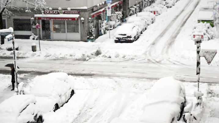 02.12.2023, Bayern, München: Hohe Schneemassen liegen auf Autos und einer Kreuzung in der Landeshauptstadt. Schnee und Eis haben im Süden Bayerns auf den Straßen und bei der Bahn für Chaos gesorgt. Foto: Felix Hörhager/dpa +++ dpa-Bildfunk +++