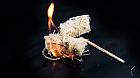 burning wood wool barbecue lighter on a black metal bowl, copy space, selected focus