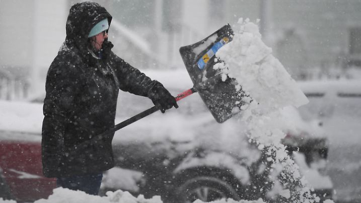 A woman throws snow while shovelling her car during the first winter storm of 2024 which is expected to bring heavy snowfall across the northeast United States, in Worcester, Massachusetts, U.S. January 7, 2024. REUTERS/Amanda Sabga
