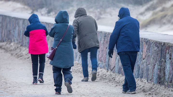 24.01.2024, Mecklenburg-Vorpommern, Rostock: Bei stürmischem Wetter sind Spaziergänger auf der Mole an der Ostseeküste unterwegs. Der Sturm bläst Sand vom Strand zum Alten Strom. An der Küste sind nach Angaben des Deutschen Wetterdienstes erneut schwere Sturmböen der Windstärke 10 möglich, auch im Binnenland soll es verbreitet stürmisch sein. Foto: Jens Büttner/dpa +++ dpa-Bildfunk +++