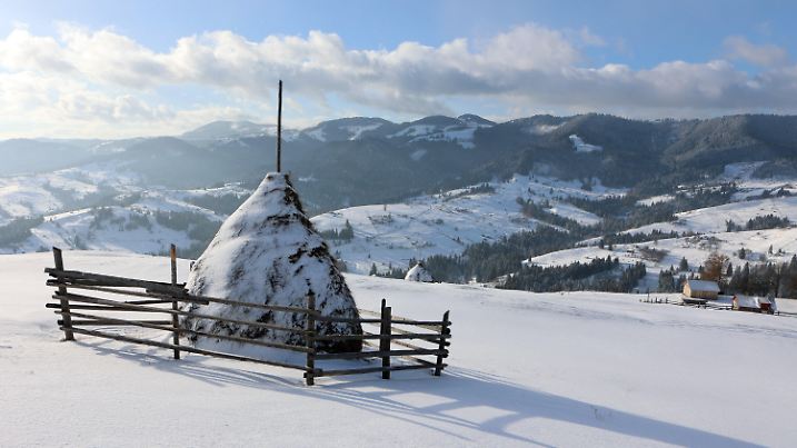 21.01.2024, Ukraine, Iwano-Frankiwsk: Ein Heuhaufen liegt an einem schneebedeckten Hang. Foto: ---/https://photonew.ukrinform.com/ Ukrinform/dpa +++ dpa-Bildfunk +++