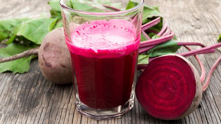 Beetroot juice and fresh beetroot on rustic wooden table