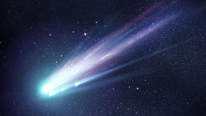 A bright comet with large dust and gas trails as the comets orbit brings it close to the Sun. Illustration.
