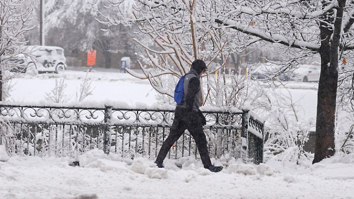 14.03.2024, USA, Denver: Ein Fußgänger geht den Speer Boulevard entlang, während ein später Wintersturm bis zu einem Meter Schnee fallen lässt. Vorhersagen zufolge wird der Sturm bis zum frühen Freitag andauern und den Verkehr entlang der Front Range von Colorado behindern. Foto: David Zalubowski/AP/dpa +++ dpa-Bildfunk +++
