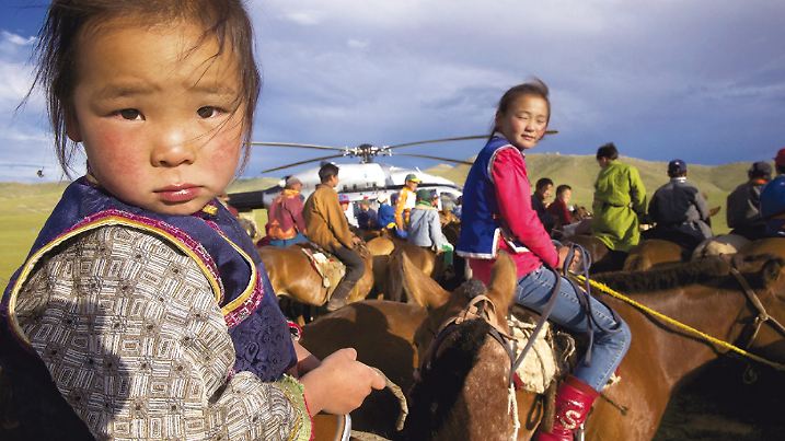 In der Mongolei bereiten sich Kinder auf ein Pferderennen vor.