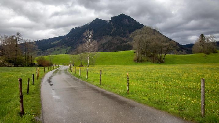 Regenwetter in Bayern Dunkle Regenwolken sind am Nachmittag bei Burgberg im Allgäu über den grünen Wiesen mit Löwenzahn zu sehen., Burgberg Deutschland *** Rainy weather in Bavaria Dark rain clouds are seen over the green meadows with dandelions in the afternoon near Burgberg in Allgäu , Burgberg Germany
