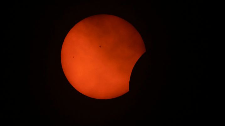 Clouds roll by as the beginning phase of a total solar eclipse is visible from Arlington, Texas, Monday, April 8, 2024. (AP Photo/Julio Cortez)