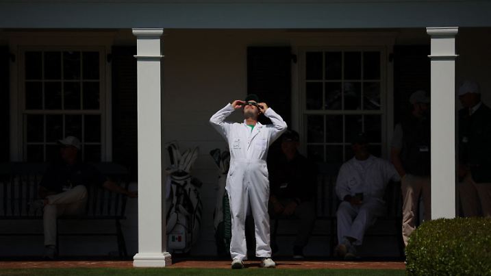 Golf - The Masters - Augusta National Golf Club, Augusta, Georgia, U.S. - April 8, 2024   General view as a caddie uses special protective glasses to observe a total solar eclipse during a practice round REUTERS/Brian Snyder