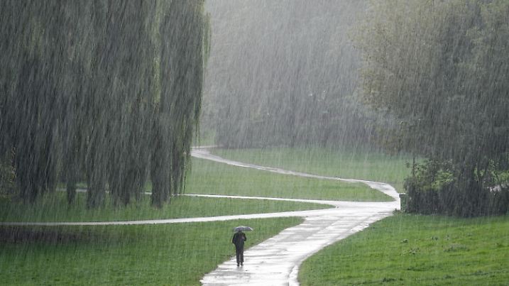20.09.2022, Berlin: Ein Passant geht im strömenden Regen durch den Rudolph-Wilde-Park. Sonne und Regen wechseln sich zur Zeit in der Hauptstadt ab. Foto: Kay Nietfeld/dpa +++ dpa-Bildfunk +++