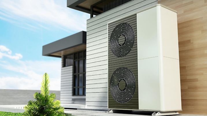 Heat pumps outside the modern house, installed near the wall.